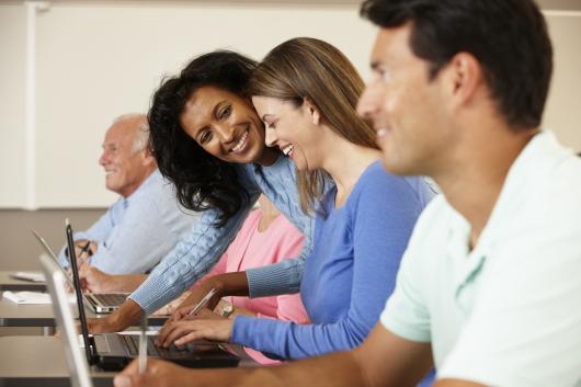 Grant Program for Exonerees and their Dependents - People at laptops smiling