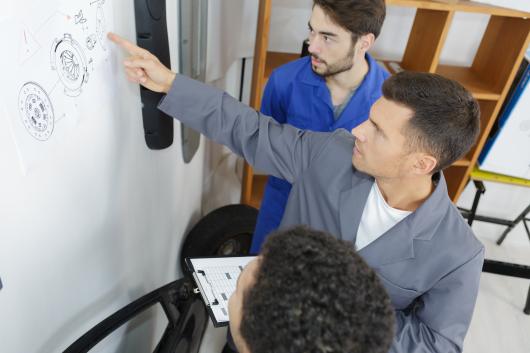 Grant Program for Exonerees and their Dependents - 3 people discussing a technical diagram