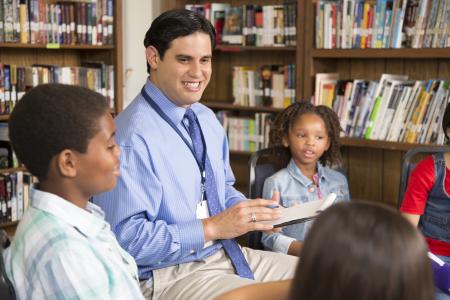 Post-MSW School Social Work Professional Educator License Scholarship Program - Professional talking with children in a library
