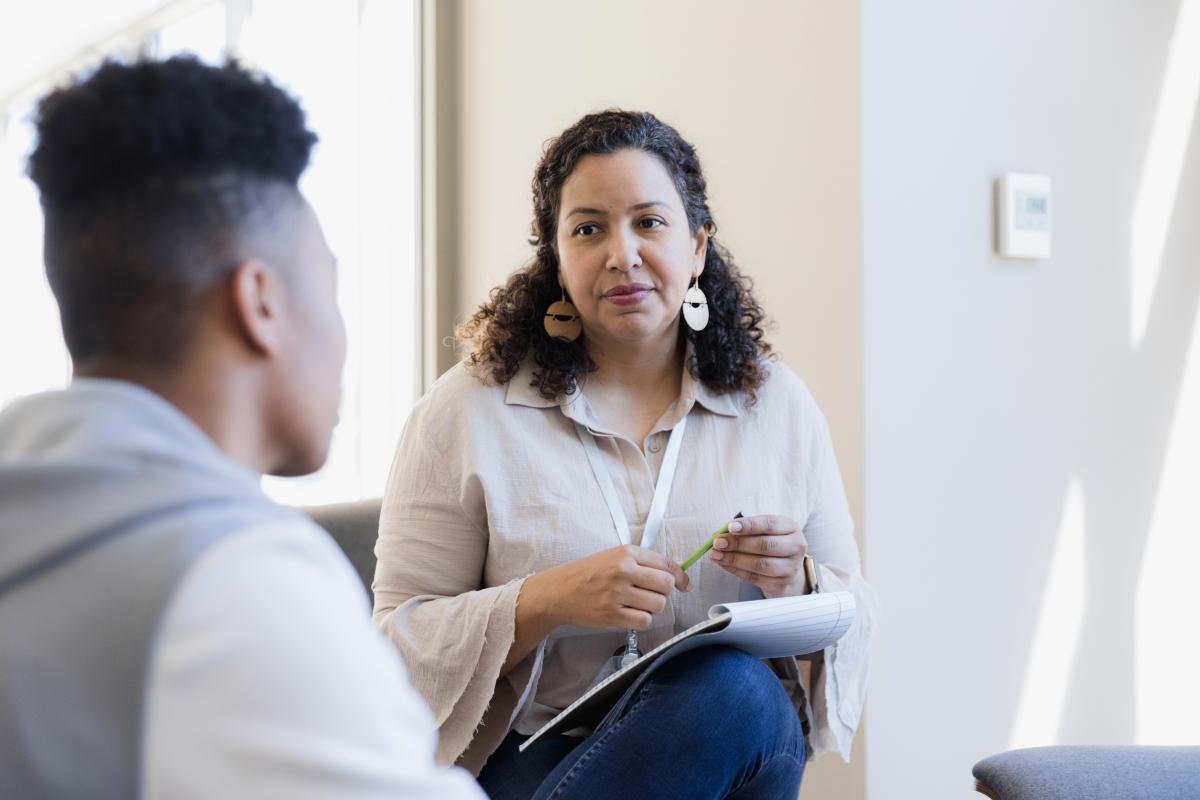 School and Municipal Social Work Shortage Loan Repayment Program - Professional with a notepad conversing with a young adult