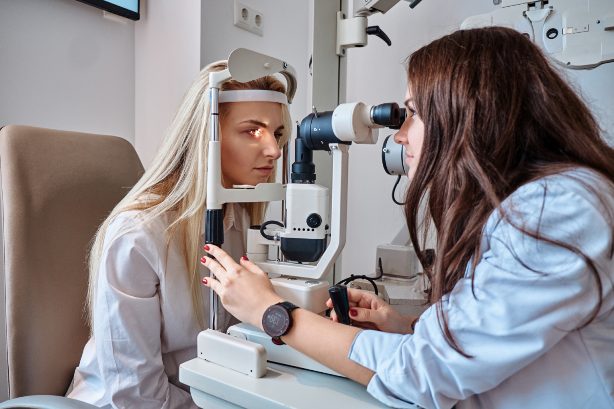 Optometrist testing patient using a machine