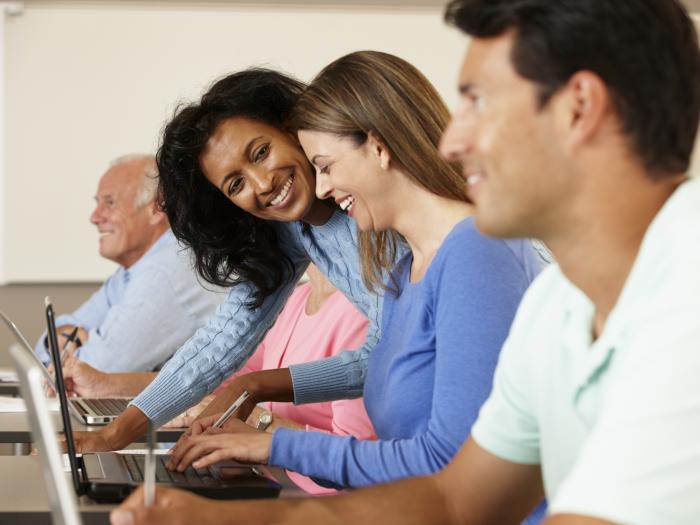 Grant Program for Exonerees and their Dependents - People at laptops smiling