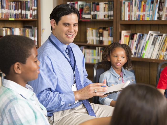 Post-MSW School Social Work Professional Educator License Scholarship Program - Professional talking with children in a library