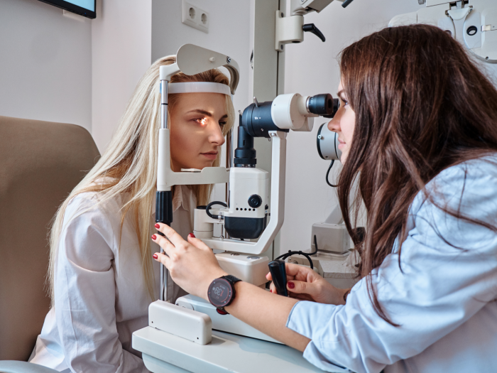 Optometrist testing patient using a machine